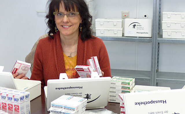 Haus- und Reiseapotheken Eine Frau sortiert Haus- und Reiseapotheken