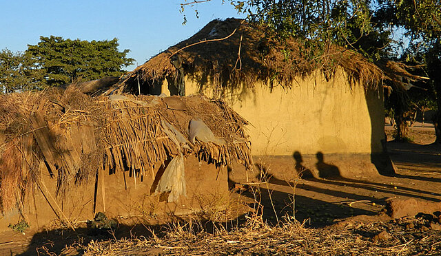 Psychische Gesundheit Ein Dorf in Malawi mit Schatten von Menschen