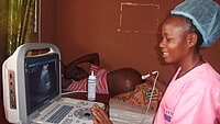 Eine Hebamme untersucht eine Schwangeren in Guinea mit Ultraschall